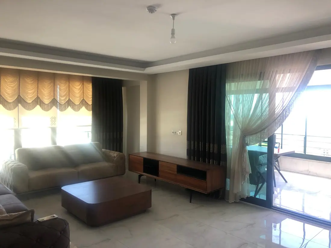 Balkon manzaralı salonda fon perde uygulaması